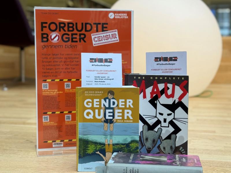 Fem bøger opstillet på en scene