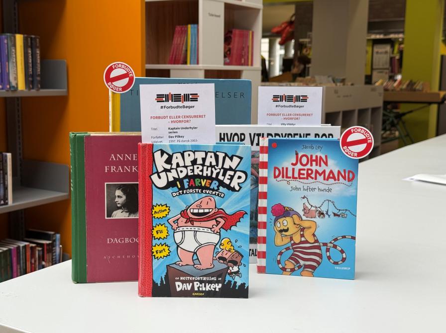 Fem børnebøger opstillet på et bord