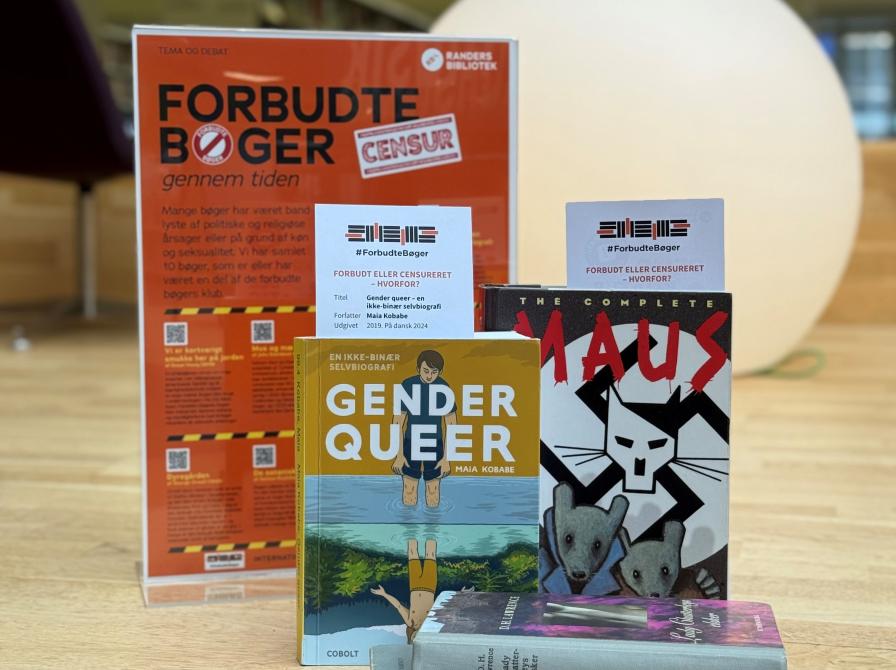 Fem bøger opstillet på en scene